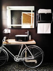 una bicicleta en un baño con lavabo y espejo en El Encino Cabin in Real del Monte en Mineral del Monte