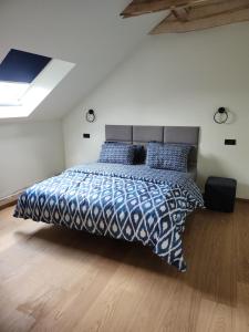 a bedroom with a bed with a blue and white comforter at Blue Door Apartment Loft in Augustów