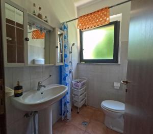 baño con lavabo y aseo y ventana en Stanza Venere, en Mornago