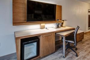 Habitación con escritorio con silla y TV. en Courtyard by Marriott Nashville Vanderbilt West End, en Nashville