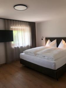 una camera da letto con un grande letto bianco e una finestra di Linderhof a Naz-Sciaves