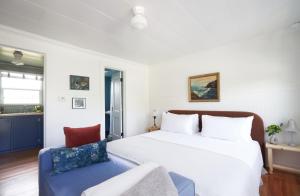 sypialnia z białym łóżkiem i niebieskim krzesłem w obiekcie The Drifthaven at Gearhart w mieście Gearhart