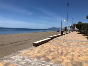a sandy beach next to the ocean with a street light at Ático en la playa con terraza privada in Cala del Moral