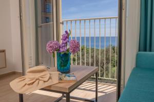 a vase of purple flowers on a table on a balcony at Apartments Bonazza in Petrovac na Moru