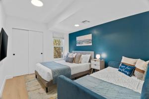 a bedroom with two beds and a couch and a blue wall at Stylish Phoenix Townhome - Central Location & Sleeps 8 in Phoenix