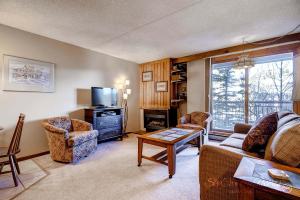 a living room with a couch and a tv at RECENTLY UPDATED Ski In & Out Condo with Heated Garage Parking and VIEWS! TE303 in Breckenridge