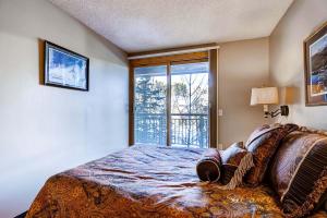 a bedroom with a bed and a large window at RECENTLY UPDATED Ski In & Out Condo with Heated Garage Parking and VIEWS! TE303 in Breckenridge