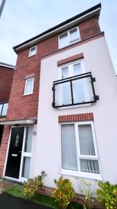 un edificio blanco con ventanas laterales en 3 stories, 5 BR House in Prime Location with balcony and shared Garden, en Liverpool