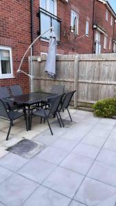 a patio with a table and chairs and a fence at 3 stories, 5 BR House in Prime Location with balcony and shared Garden in Liverpool
