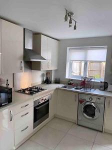 a kitchen with a stove and a washing machine at 3 stories, 5 BR House in Prime Location with balcony and shared Garden in Liverpool