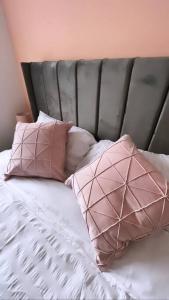 a bed with two pink pillows on it at 3 stories, 5 BR House in Prime Location with balcony and shared Garden in Liverpool