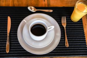 una taza de café en un plato en una mesa en Pousada Capitólio, en Capitólio