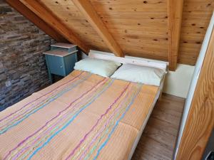 duże łóżko w pokoju z drewnianym sufitem w obiekcie House Riva w mieście Pirovac