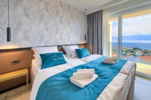 a bedroom with a large bed with blue and white pillows at Villa See Vrbnik in Vrbnik