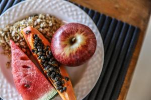 a plate of food with fruit on a table at Pousada Capitólio in Capitólio