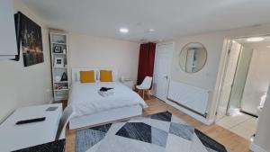 een slaapkamer met een wit bed en een tapijt bij Lovely studio-flat with free parking, free WiFi. in Leeds