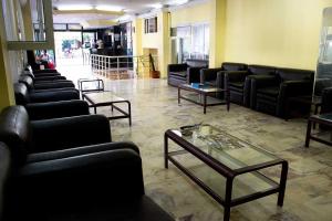 una sala d'attesa con divani neri e tavolo di Ares City Hotel a Kemer