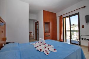 ein Schlafzimmer mit einem blauen Bett und Handtüchern darauf in der Unterkunft Denise Hotel in Skopelos