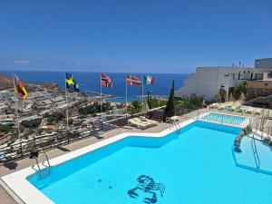 a large swimming pool with a view of the ocean at Horizon Views - Excellent location with ocean view in Puerto Rico de Gran Canaria