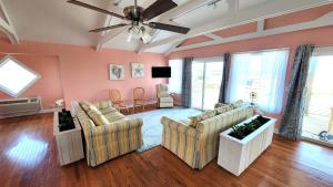 a living room with two couches and a ceiling fan at 8018 Beach Rd, Semi-Oceanfront, Pool/Hot Tub in Nags Head
