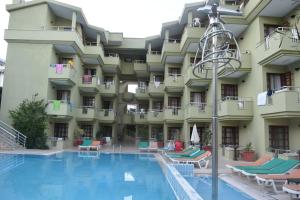 um hotel com piscina em frente a um edifício em Ares City Hotel em Kemer