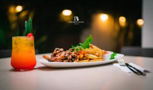 un plato de comida con papas fritas y una bebida en una mesa en RBB BRITO HOTEL, en Tarapoto