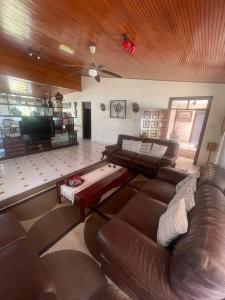 The Embassy Residence في مومباسا: غرفة معيشة مع أثاث جلدي بني وسقف