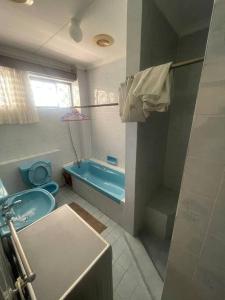 The Embassy Residence في مومباسا: حمام مع حوض استحمام أزرق ومرحاض