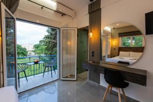 a room with a view of a bedroom and a balcony at Zografos Rental Rooms in Nafpaktos