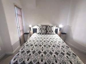 - un lit avec une couette en noir et blanc dans l'établissement Appartement Le Fort 2 Vue Montagne, à Villefranche-de-Conflent