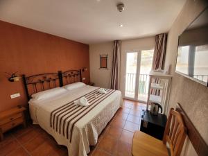 Schlafzimmer mit einem Bett und einem Fenster in der Unterkunft Hostal Jayma in Salobreña