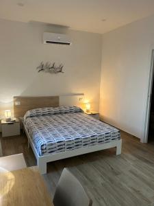 een witte slaapkamer met een bed en een tafel bij Stella di Mare in Civitavecchia