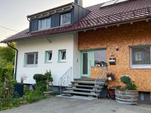 une maison avec une porte et des escaliers verts dans l'établissement Ferienwohnung im Obstgarten, à Achberg