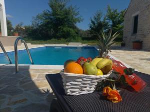 a basket of fruit on a table next to a pool at Leggiero in Benkovac