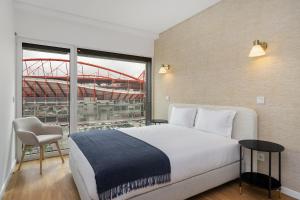 a bedroom with a bed and a view of a stadium at WHome Urban Retreat w/Parking, Elevator & AC by Benfica Stadium in Lisbon