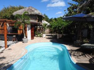 a swimming pool in front of a house at Pousada Santa Aldeia in Barra Grande