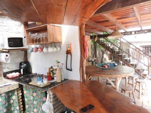 cocina con mesa, sillas y barra en Pousada Santa Aldeia, en Barra Grande