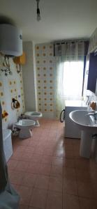 uma casa de banho com 2 lavatórios e 2 WC em Casa vacanze CALU' em Cittadella del Capo