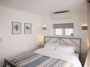 a white bedroom with a bed and two pictures on the wall at Ocean View apartment, beautiful sea views in Kent