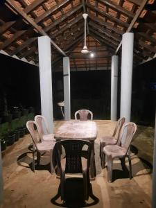 a table and chairs in a room with a table and chairs at Green Stay in Habaraduwa Central