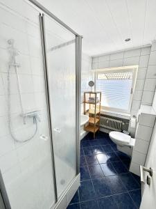 een badkamer met een douche, een toilet en een wastafel bij BocholtApartments in Bocholt