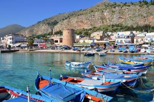 a group of boats in the water near a town at Clio's House - Mondello in Mondello