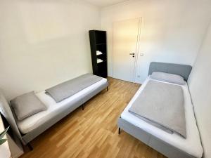een kleine kamer met 2 bedden en een kast bij BocholtApartments in Bocholt
