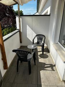 een balkon met 2 stoelen en een tafel en een stoel bij BocholtApartments in Bocholt