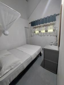 a small bedroom with a bed and a sink at Green Stay in Habaraduwa Central