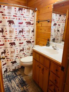 La salle de bains est pourvue de toilettes et d'un rideau de douche avec des animaux. dans l'établissement Smoky Mountain Enchanting Haven 3BR2BA Cabin, à Sevierville