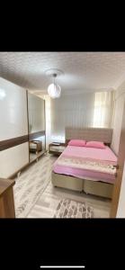 um quarto com uma cama rosa num quarto em Geyikli Ada Apart Otel em Geyikli