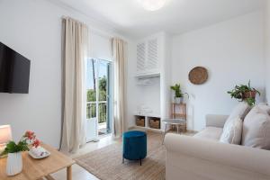 Sala de estar blanca con sofá y mesa en Reana Elegant Apartments en Barbati