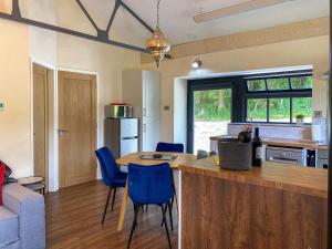 a kitchen with a table and blue chairs in a room at Tranquillity-uk38552 in Endon