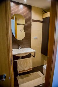 La salle de bains est pourvue d'un lavabo, d'un miroir et de toilettes. dans l'établissement Mirador Islas de Arosa, à Ribeira